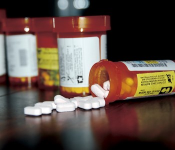 Pharmaceuticals - white pills spilling out of a prescription pill bottle