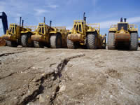 Large construction equipment on a dirt field.