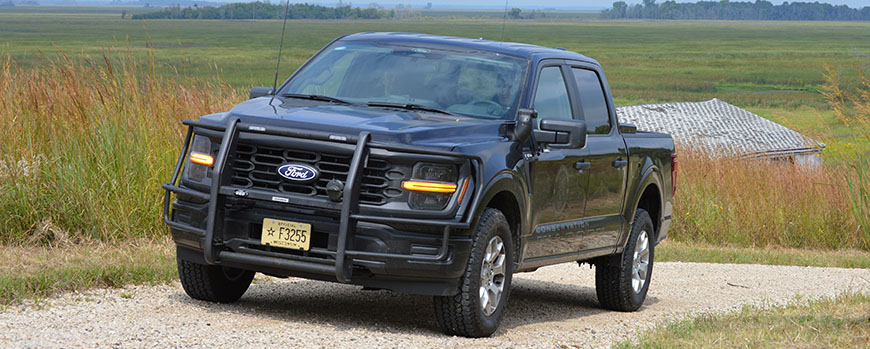 A new conservation warden truck on a rural gravel road.