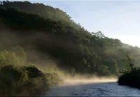 A bend in the Kinnickinnic River with a hill risin behind.